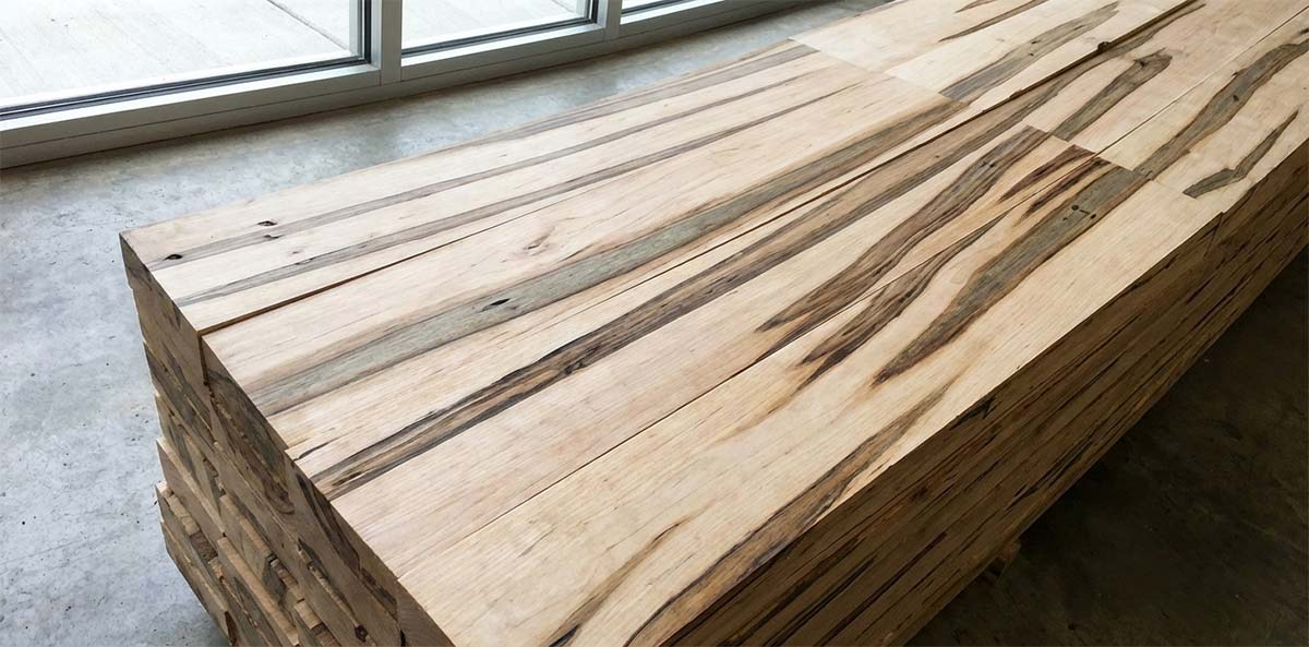 Stacked ambrosia maple lumber with long streaks following the wood grain