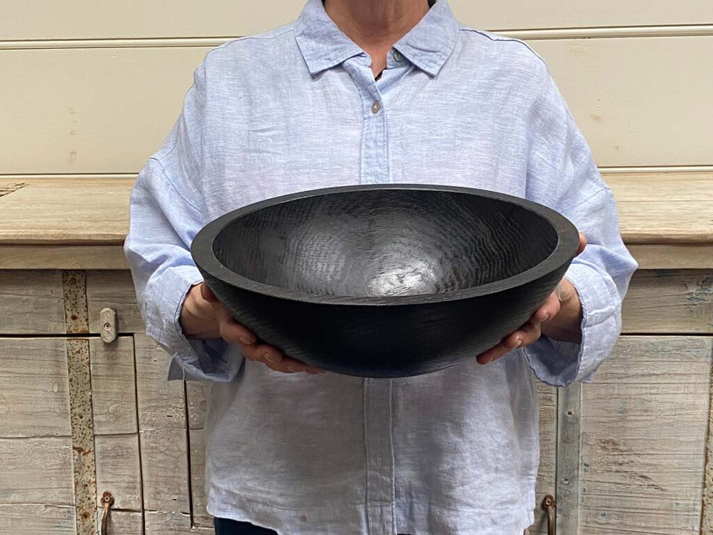 Medium 13-inch ebonized oak round wooden bowl, smooth dark finish highlighting oak grain.
