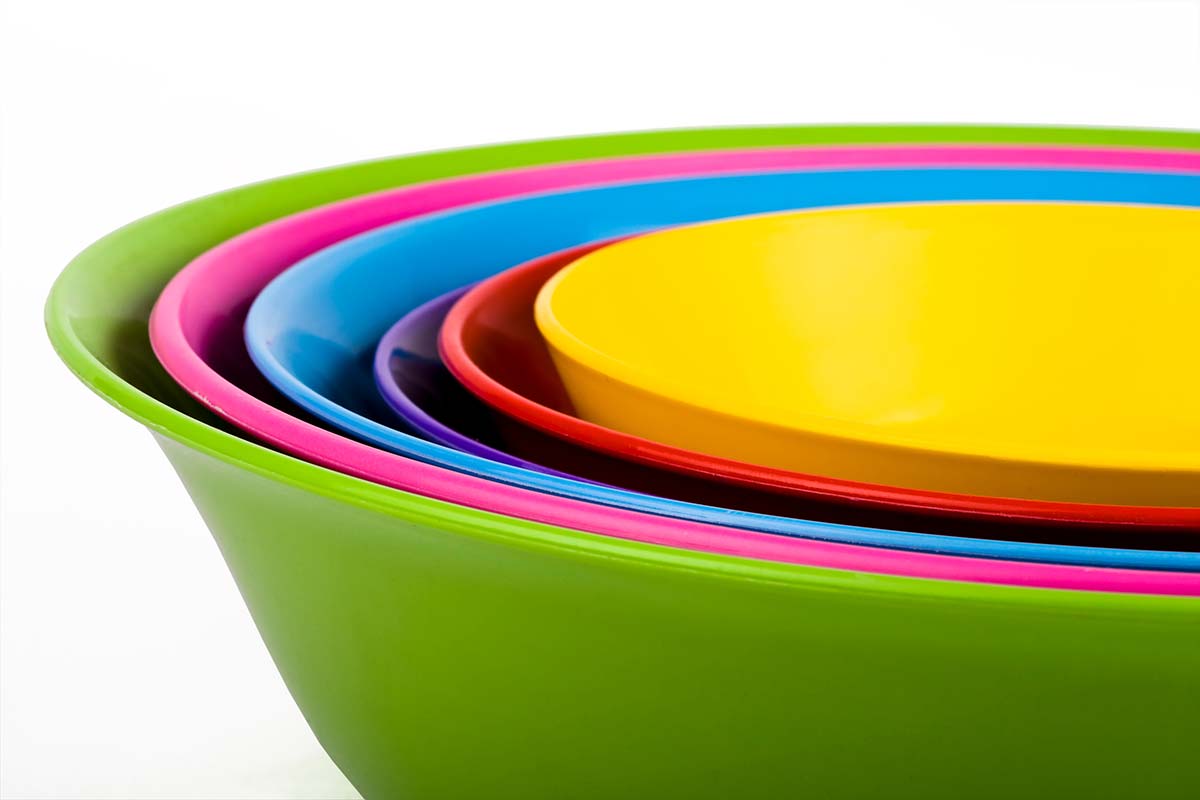 Colorful plastic serving bowls nested together — used to compare wooden vs. plastic serving bowls.