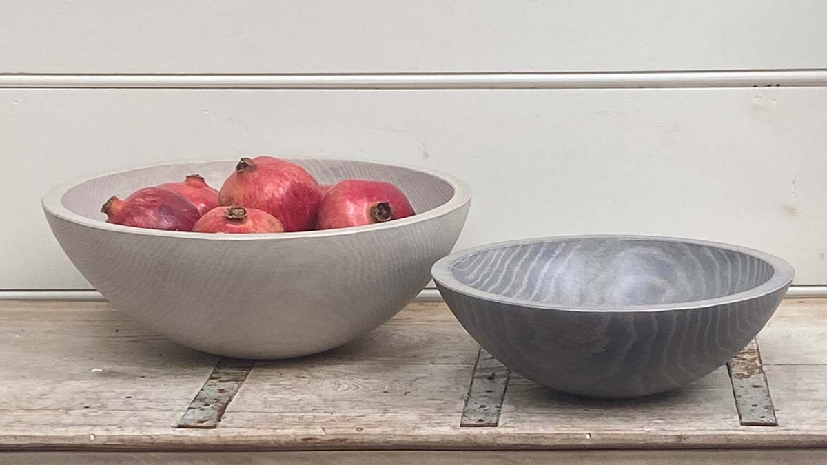 White Pearl and driftwood bowls by Spencer Peterman displayed on an antique cabinet