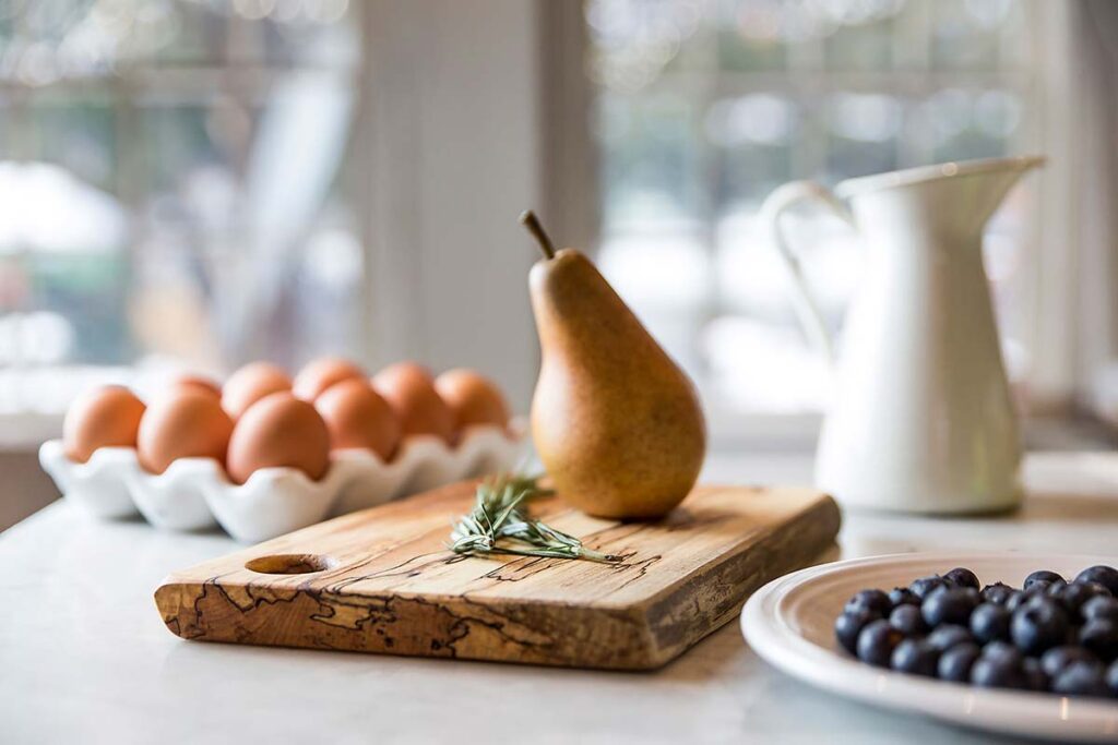 Handmade wooden cutting board displayed on a kitchen breakfast table