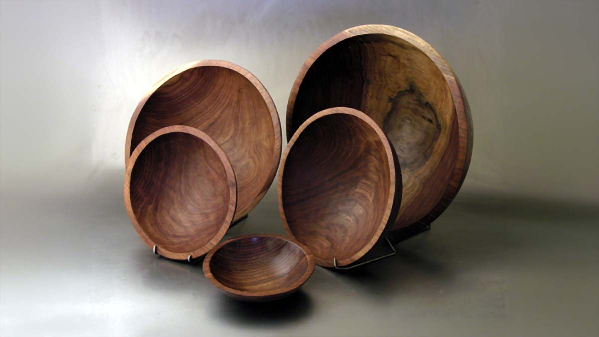 Set of handcrafted black walnut wooden bowls in graduated sizes displayed together