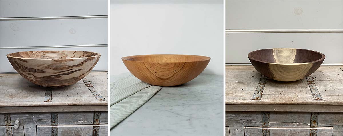 Three handcrafted wooden salad bowls showing different wood grain patterns