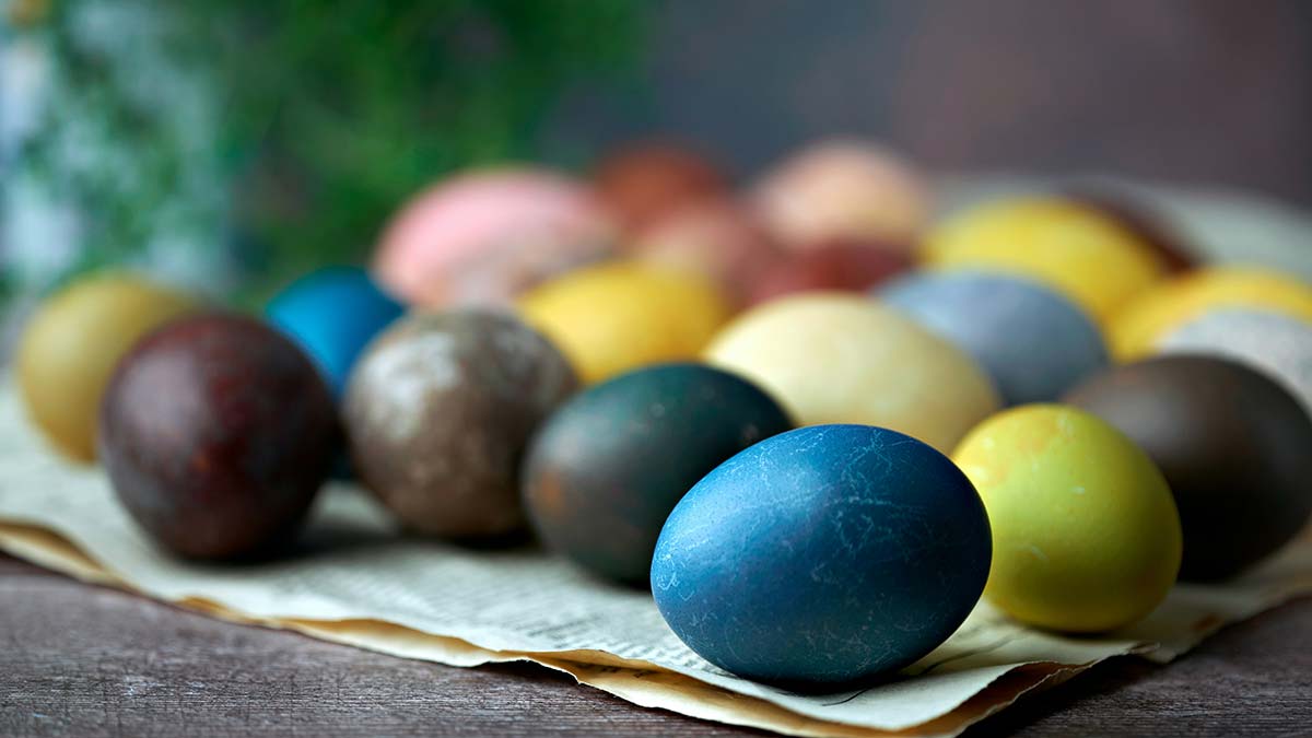 Hand-dyed eggs resting on paper, seasonal table display for spring gatherings