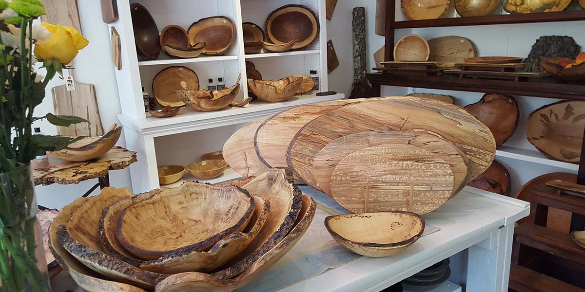 Interior of Spencer Peterman gallery in Gill, Massachusetts with shelves of handcrafted wooden bowls and boards