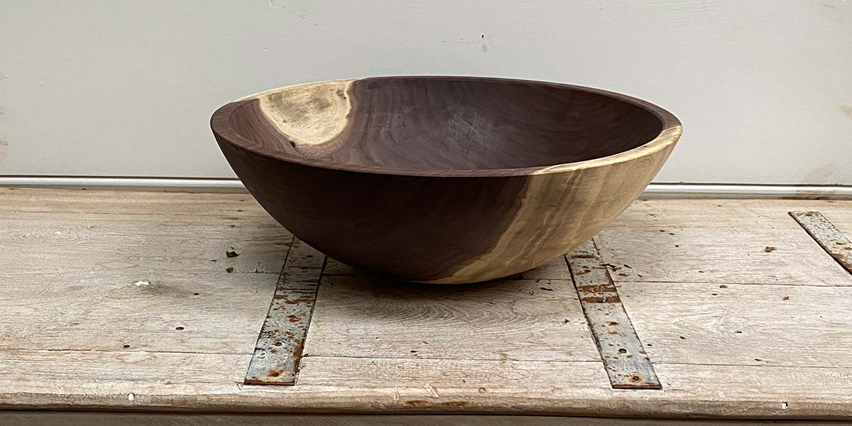 Black walnut wooden salad bowl on a marble surface