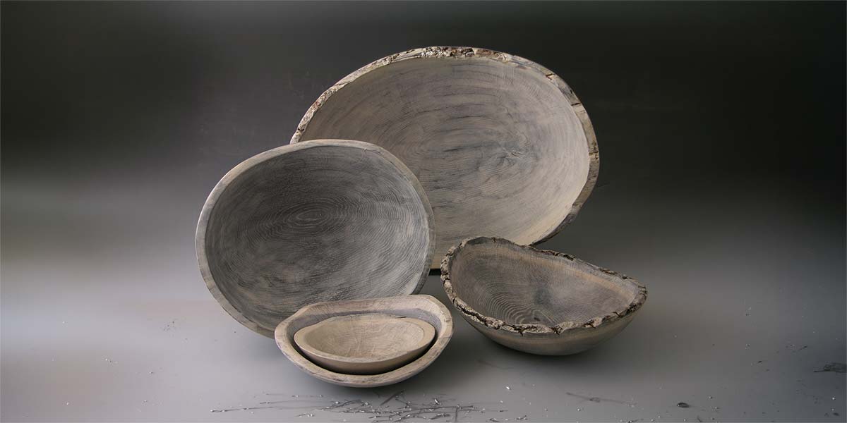 Set of driftwood-style wooden bowls with natural edges and varied grain patterns