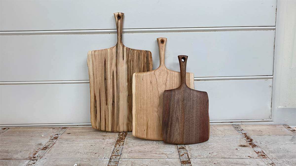 Heirloom gifts for mom collection of wooden serving and cutting boards with handles in varied wood tones and shapes