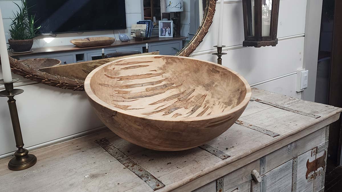 Ambosia maple wooden bowl displayed on wooden cabinet